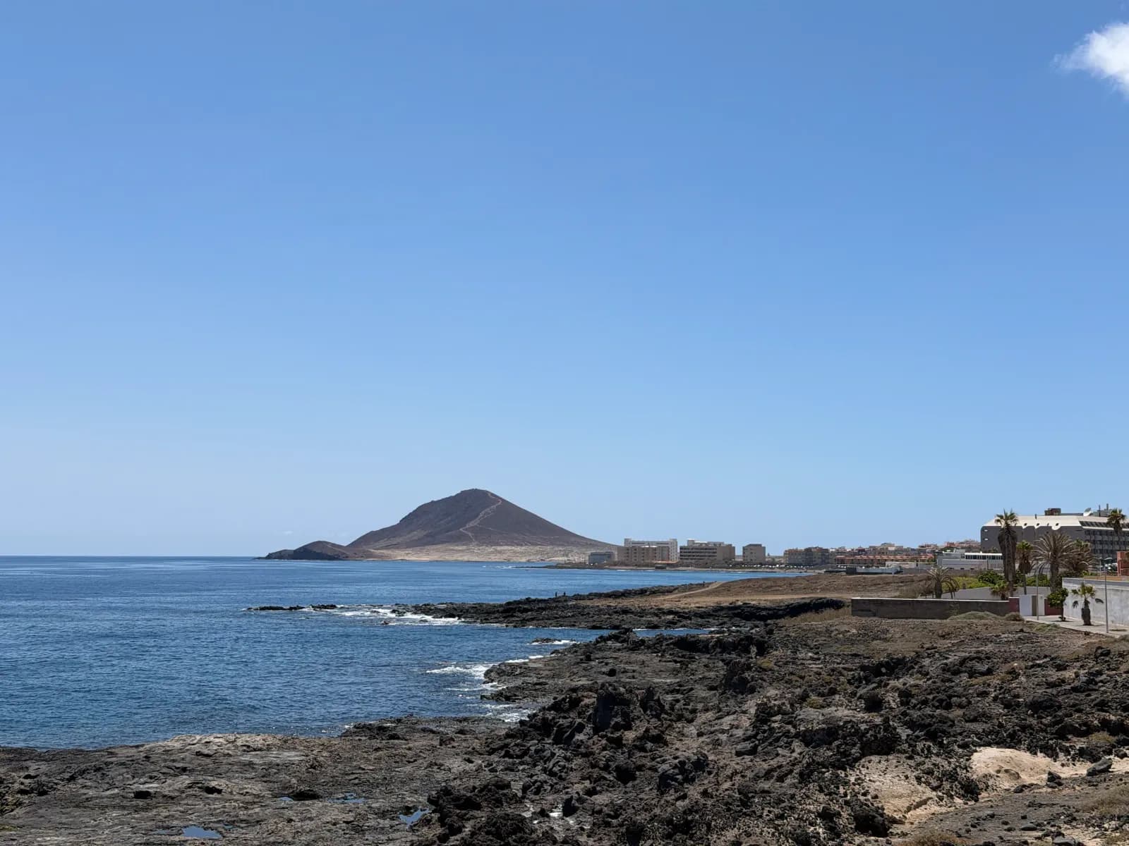 Lawowe wybrzeże przy Avenida de Europa w El Médano z widokiem na stożek Montaña Roja i ocean