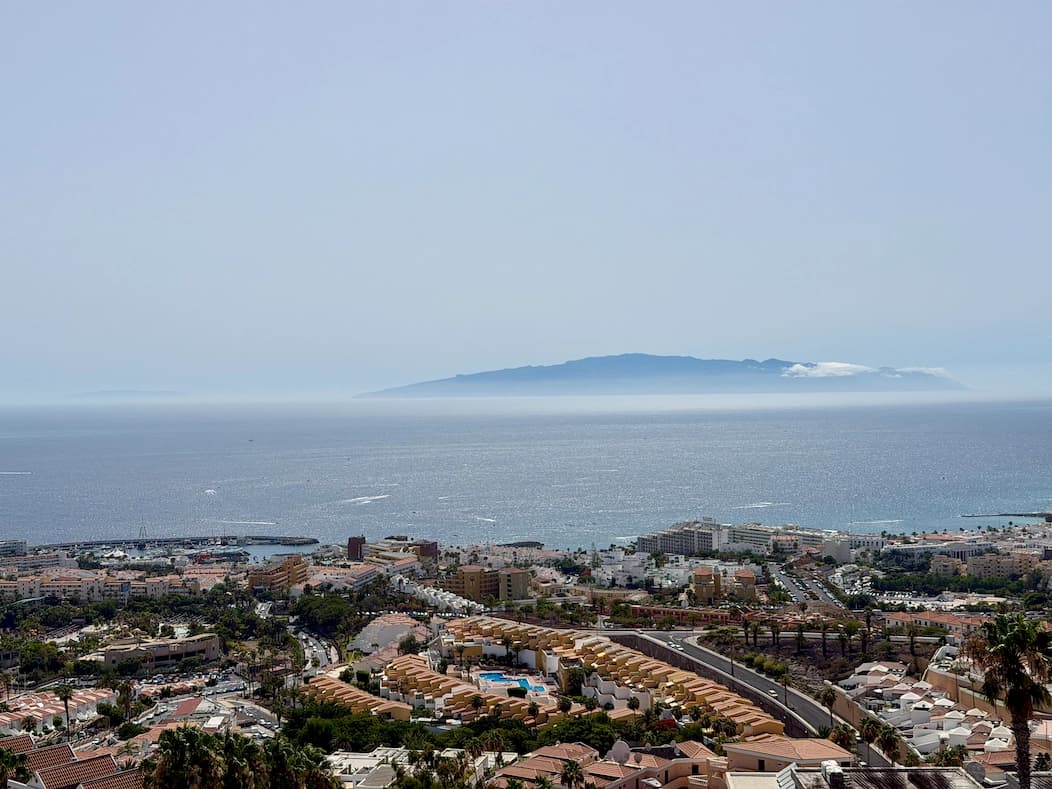 Panorama Costa Adeje ze wzgórz Adeje – marina przy plaży La Pinta, zabudowa kurortu i wyspa La Gomera na horyzoncie