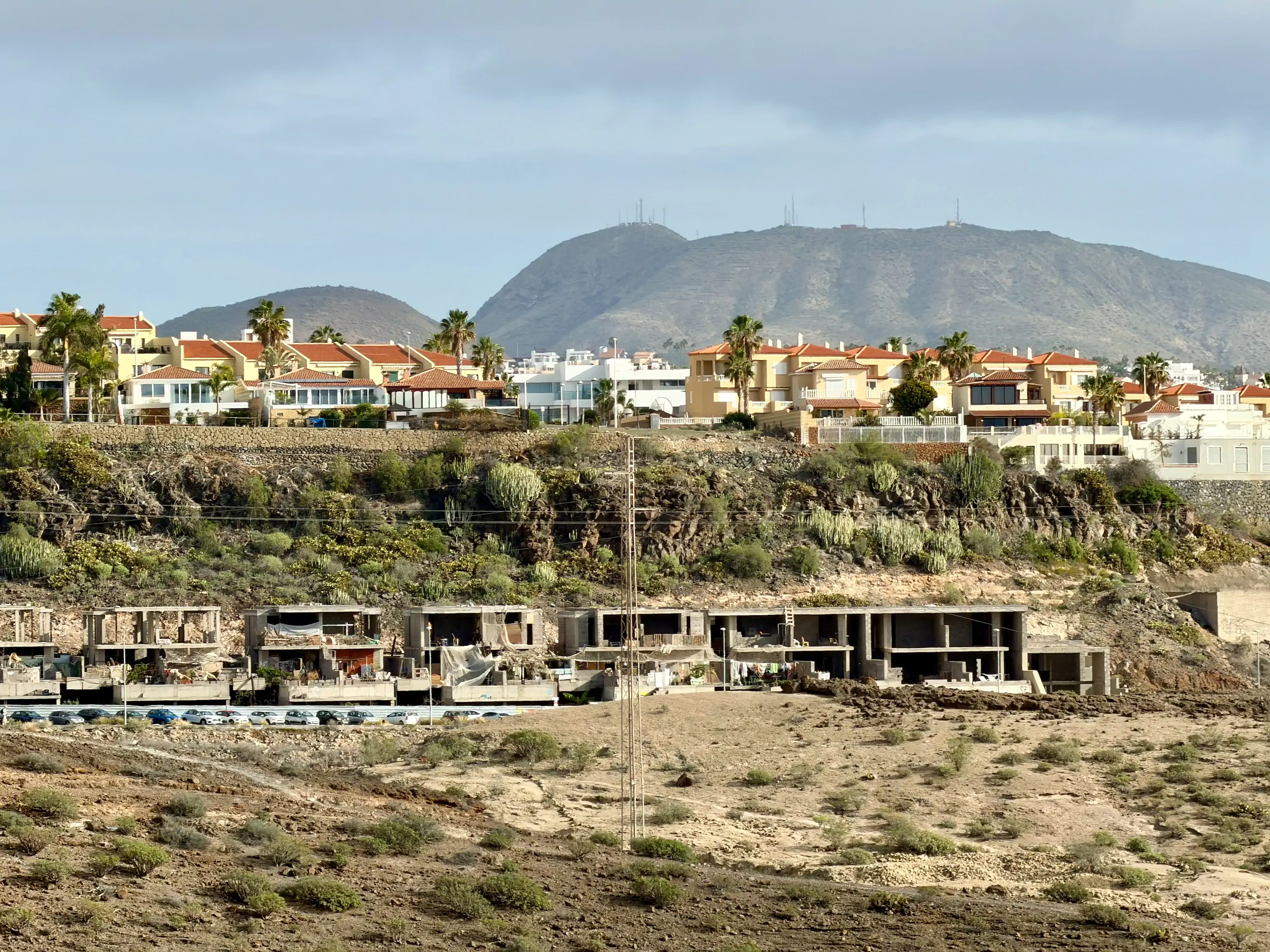 Kontrast na Teneryfie: na górze luksusowe wille z czerwonymi dachami, na dole porzucony betonowy szkielet budowy