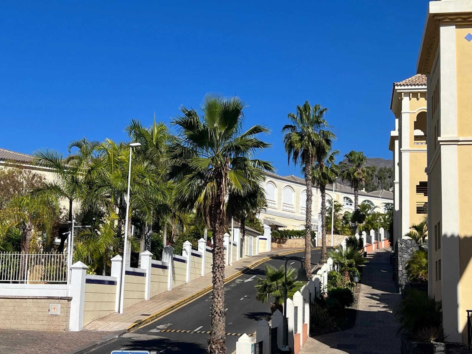 Para oglądająca dokumenty przy laptopie z widokiem na ocean i apartamenty na Teneryfie